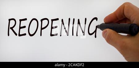 Hand writing 'reopening', isolated on beautiful white background. Concept. Stock Photo