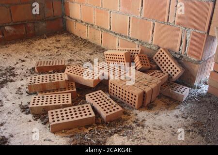 a stack of red bricks to build a residential house within the structure Stock Photo