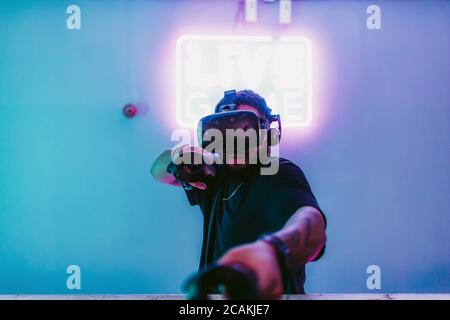 The guy in the game outfit in the neon room. Stock Photo