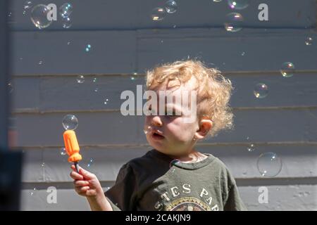 Denver, Colorado - Two-year-old Hendrix Hjermstad is fascinated by bubbles created by a bubble machine. Stock Photo