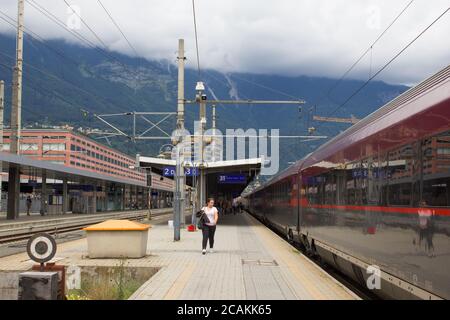 April 2020 - Innsbruck / Austria: An Austrian OBB railway train departing from the platform on the Innsbruck Main Railway Station on a cloudy day with Stock Photo