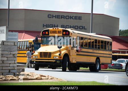 Canton, GA, USA. 7th Aug, 2020. Cherokee High School buses leave school with students at end of first week of in-person fall classes during pandemic worries. The school system mandate masks for all faculty and staff, but declined to insist students wear them. Administrators admitted the county is under a ''˜national microscope' as it reopened face-to-face classes as Covid-19 cases surged in Georgia. Credit: Robin Rayne/ZUMA Wire/Alamy Live News Stock Photo