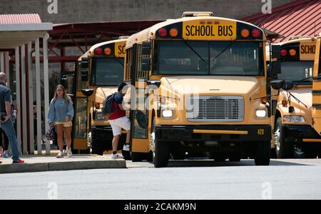 Canton, GA, USA. 7th Aug, 2020. Cherokee High School buses leave school with students at end of first week of in-person fall classes during pandemic worries. The school system mandate masks for all faculty and staff, but declined to insist students wear them. Administrators admitted the county is under a Ã”national microscopeÃ as it reopened face-to-face classes as Covid-19 cases surged in Georgia. Credit: Robin Rayne/ZUMA Wire/Alamy Live News Stock Photo