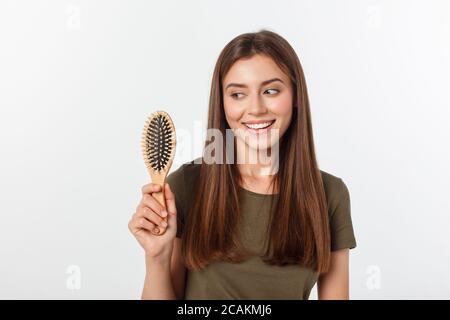 Happy young woman combing her long healthy hair on white background. Stock Photo
