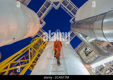 Engineering climb up to oil and gas process plant to observer gas dehydration processing in night shift Stock Photo