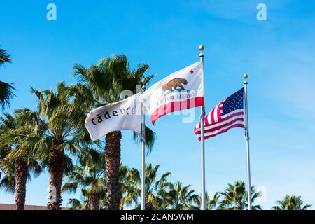 Flag of the United States, Flag of California and Cadence Flag flying waving in wind under blue skies above Cadence Design Systems, Inc Campus in Sili Stock Photo