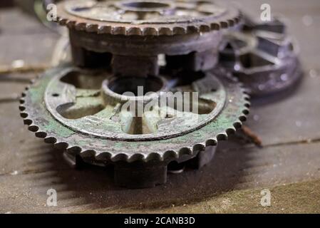 Old motorcycle drive stars on the desktop in the garage, motorcycle spare parts. Stock Photo