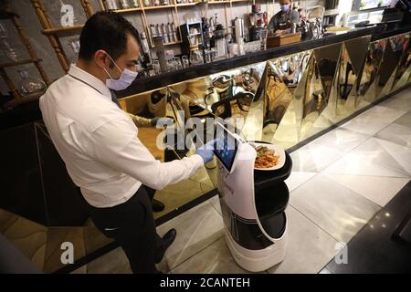 Cairo, Egypt. 7th Aug, 2020. A waiter sets the table number for the robot delivery at Kimbo Restaurant & Cafe in Cairo, Egypt, on Aug. 7, 2020. For the first time in Egypt, a restaurant has hired a robot to assist in serving the customers to maintain social distancing amid the COVID-19 pandemic. TO GO WITH 'Feature: Egyptian restaurant hires robot waiter to maintain social distancing amid COVID-19 outbreak' Credit: Ahmed Gomaa/Xinhua/Alamy Live News Stock Photo