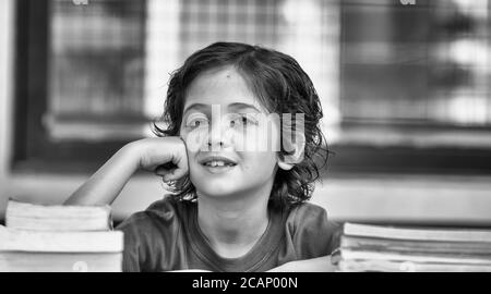 Happy caucasian boy in the classroom thinking. Back to school concept. Stock Photo