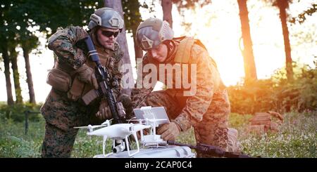 Modern Warfare Soldiers Squad are Using Drone for Scouting and Surveillance During Military Operation in the Forest. Stock Photo