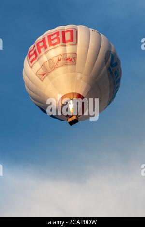 Vilnius/Lithuania - 2020-08-02: Hot air balloons from below raging through a clear light blue sky with many people inside Stock Photo