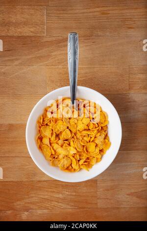 Cereal Bowl with spoon over a wood table Stock Photo
