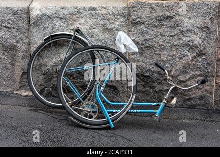 Broken bicycle leaning against wall Stock Photo