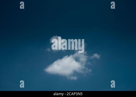 Minimal lonely white cloud in deep blue sky background Stock Photo