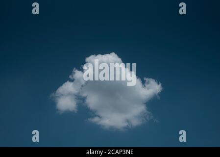 Minimal lonely white cloud in deep blue sky background Stock Photo