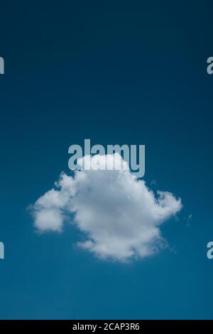 Minimal lonely white cloud in deep blue sky background Stock Photo