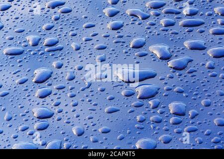 Water droplets on a highly polished blue car bonnet Stock Photo