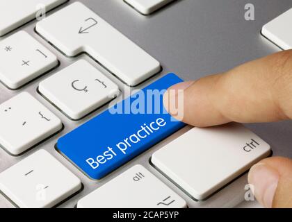 Best practice Written on Blue Key of Metallic Keyboard. Finger pressing key. Stock Photo