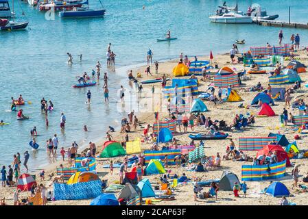 Lyme Regis, Dorset, UK. 8th August 2020. UK Weather: Crowds of holidaymakers and sunseekers pack out the beach at the seaside resort of Lyme Regis, Dorset to bask in another day of sizzling hot sunshine as the heatwave continues.The beach was already busy at 10.30. Credit: Celia McMahon/Alamy Live News.