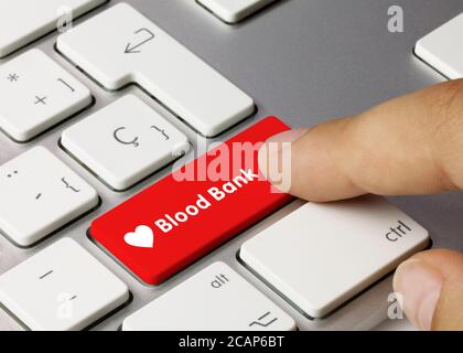 Blood Bank Written on Red Key of Metallic Keyboard. Finger pressing key Stock Photo