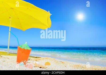 beach umbrella and cocktail under a bright sun Stock Photo