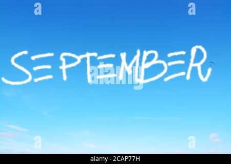 september written in the sky with contrails Stock Photo