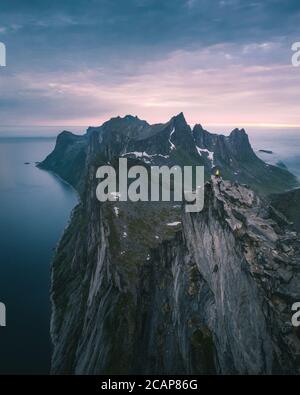 Woman standing at the top of Segla mountain in Senja, Norway. Stock Photo