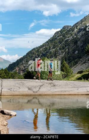 Coma Pedrosa, Andorra : 02 August 2020 :  Group of tourists resting at Lago de les Truites in Andorra Pyrenees in summer 2020. Stock Photo