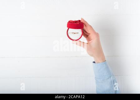 Open red jewelry box with ring in female hand. Present. White background Stock Photo
