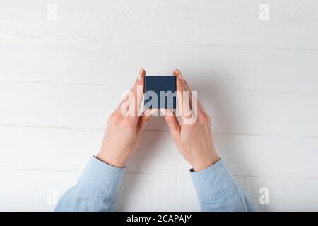Small blue box in female hands. Present. White background Stock Photo