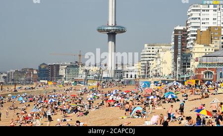 Brighton UK 8th August 2020 - Brighton beach is already busy on another hot day as the temperature is forecast to reach over 30 degrees in some parts of the South East : Credit Simon Dack / Alamy Live News Stock Photo