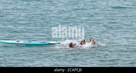 Brighton UK 8th August 2020 - Fun in the sea off Brighton beach on another hot day as the temperature is forecast to reach over 30 degrees in some parts of the South East : Credit Simon Dack / Alamy Live News Stock Photo
