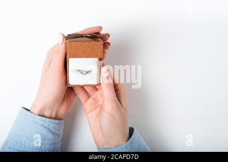 Open brown jewelry box with ring in female hand. Present. Isolate Stock Photo