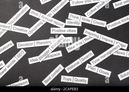 Word cloud of business themes cut out of paper on a gray background. Stock Photo