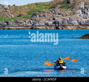 North Berwick, East Lothian, Scotland, 8th August 2020. UK Weather: Perfect day for water sports. A warm sunny day in the Firth of Forth attracts people to take to the water. A group of children have fun paddling in an inflatable canoe in West Bay Stock Photo