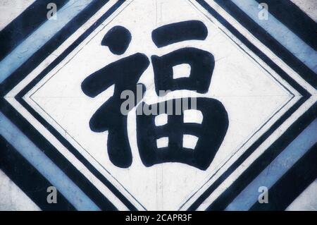 An abstract black, white and blue background with the chinese character Fu which means Good fortune or Good luck Stock Photo