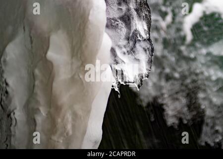 Blue gray broken glass background. Transparent ice. Vitrage. Frozen water. Pieces of glass. Gem. A circle of white light behind. Glow. Stock Photo