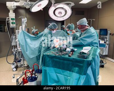 in a large operating theatre a surgical operation is performed by two ...