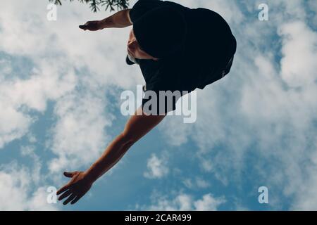 Young sporty man jump parkour. Bottom view. Stock Photo