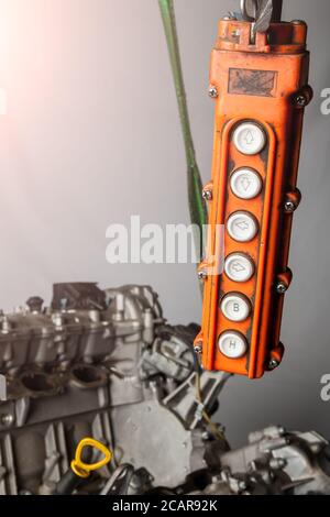 Orange control panel for a crane in an in-booster production or in a car service with buttons for moving in different directions of raising and loweri Stock Photo