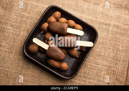 Imli stick Candy or Tamarind Lollipop is kids favourite sweet food in India Stock Photo