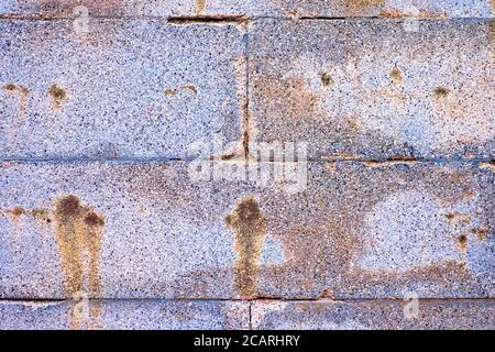 Aged colorful stone blocks, silver gray wall with rusty stains. Stock Photo