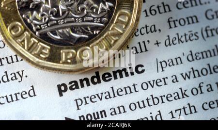 BRITISH ONE POUND COIN WITH DICTIONARY DEFINITION OF WORD PANDEMIC RE THE ECONOMY CORONAVIRUS COVID-19   GLOBAL DISEASE ETC UK Stock Photo