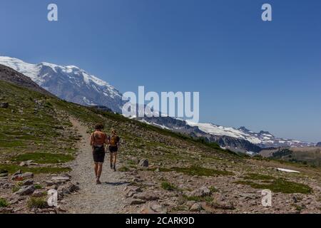 Girl and boy hiking together on the Burroughs Mountain Trail at Sunrise Park in Mt Rainier National Park in Washington State. Stock Photo