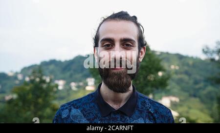 Young handsome hipster man confidently looking at camera and smiling Stock Photo