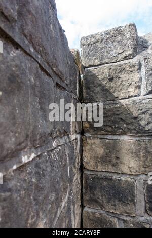 vertical crack in an old stone wall Stock Photo