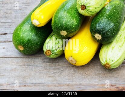 Zucchini on wooden background. Yellow and green zucchini. Vegetable marrow courgette or zucchini. Harvest courgette organic ingredient. Stock Photo