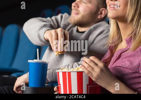Loving the movie. Cropped closeup of a happy smiling couple eating popcorn at the movies Stock Photo