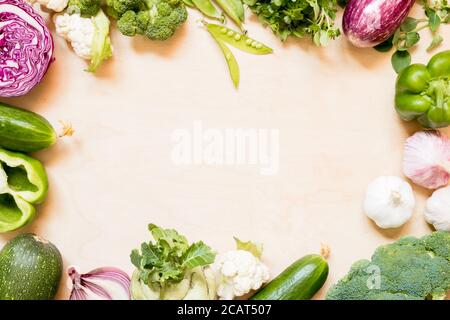 Top view set raw of green, red and purple vegetables spread on wooden background. Copy space Stock Photo