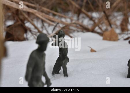 A Toy Soldier Taking Aim and Ready to Fight in Knee-Deep Snow Stock Photo